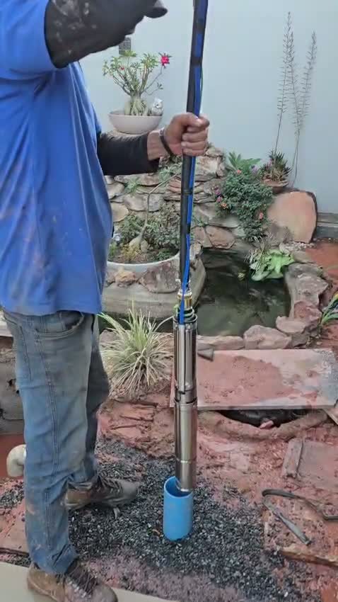 Técnico da Teglas retirando a bomba de um mini poço em quintal residencial